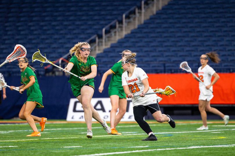 Syracuse attack Ashlee Volpe (21) looks for a shooting opening in the Orange’s four-overtime triumph against Notre Dame Saturday. Volpe poured in a season-high five points in SU’s nail-biting victory over the Fighting Irish.