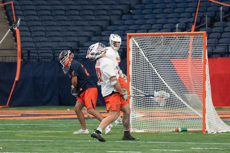 Syracuse faceoff man John Mullen (white) looks to the roof of the JMA Wireless Dome after he scored in the Orange’s 14-9 win over Virginia. Despite the win and goal, Mullen recorded a 36.4% faceoff winning percentage. 
