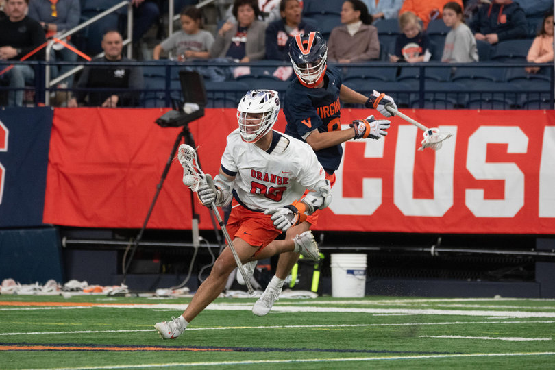 Syracuse midfield/attack Payton Anderson (white) dodges a Virginia defender in SU’s five-goal bounce-back win Saturday. Anderson notched one goal in the Orange’s triumph.
