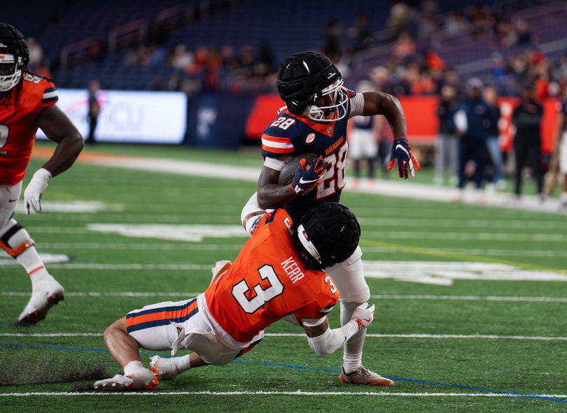 Running back Malachi Coleman (blue) escapes a tackle from defensive back Davien Kerr (orange). Head coach Fran Brown said Coleman has steadily improved across the spring, as backed by a late-game touchdown Saturday.
