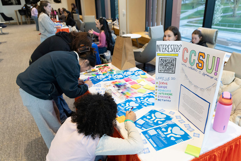 Students make friendship bracelets at the Care Collective club's table. The club, co-founded by Katherine Walters, is run by undergraduate students majoring in social work.