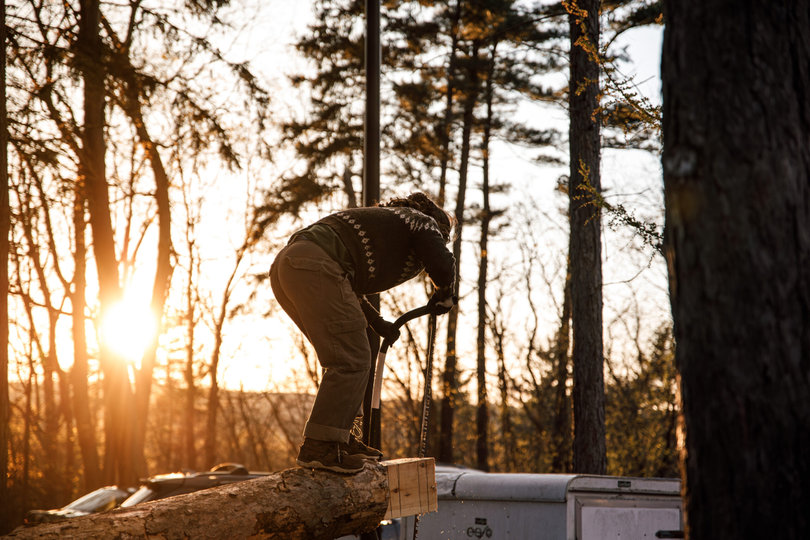 Practicing the obstacle pole event, an ESF woodsman wields a bow saw. For obstacle pole, competitors run up a diagonal log, saw off a piece of wood and run down as quickly as possible. 