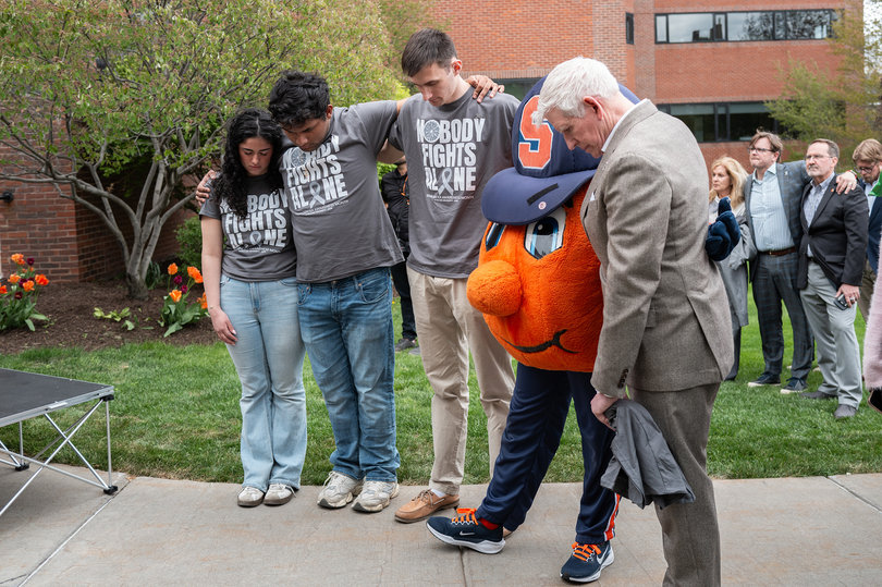 SGA President-elect Emily Castillo-Melean, outgoing President German Nolivos, Vice President-elect Max Lachut, Otto the Orange and Senior Vice President of Syracuse University Allen Groves bow their heads during prayer service. In his remarks at the end of the walk, Bartholomew asked attendees to hold a brief moment of silence.