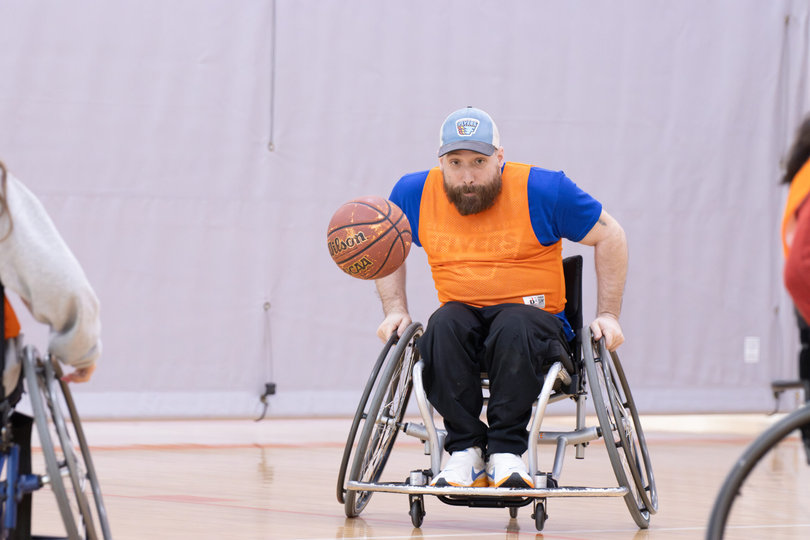 One supporter chases after a ball during a basketball match. Sports included in these events are basketball, lacrosse, sled ice hockey and rugby.