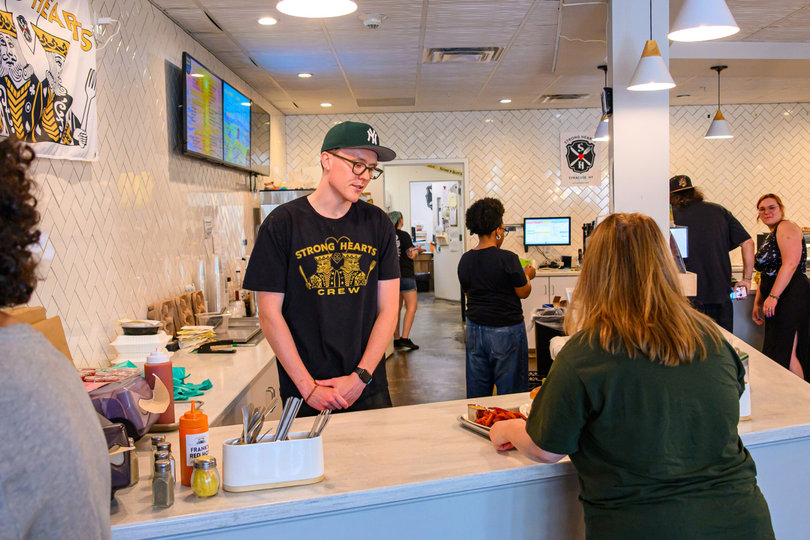 Customers enjoy their food and wait in line at Strong Hearts Cafe's Syracuse location. Founded in 2008, the vegan eatery will close both of its locations, one in Syracuse and one in Buffalo, later this month.