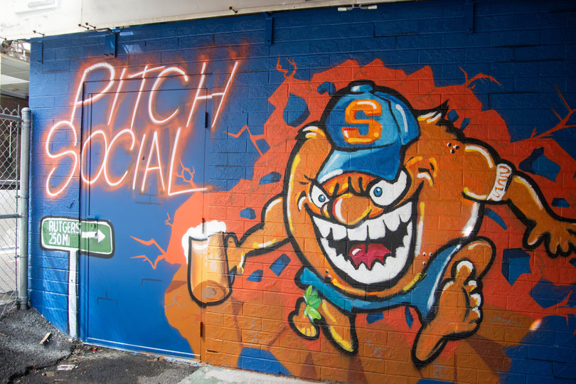 Artist Jasper Wright painted the back entrance wall of Syracuse's upcoming Pitch Social. Drew Patel founded the first-ever Pitch Social bar at Rutgers last September and is bringing the second location to Marshall Street.