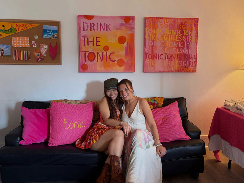 Surrounded by Tonic Girl paintings and decor, Jamie Kim (left) and Eliza Cardillo (right) sit in their apartment for their launch party. The sustainable brand aims to make clothing and swimsuits affordable for women.