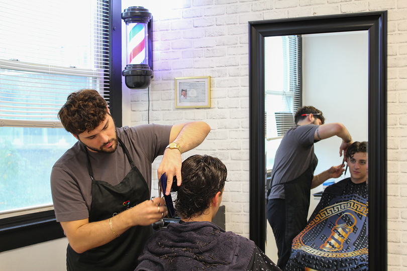 Stavros Vigliotti, owner of Garbo's Barber & Beauty, cuts a client's hair. Vigliotti worked as a barber at Garbo's for three years before buying the business in 2024.