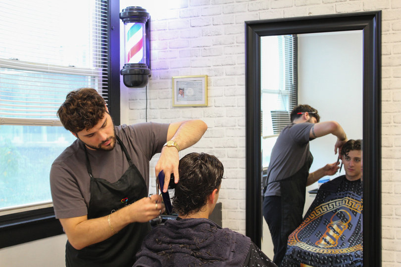 Stavros Vigliotti cuts a customer's hair at Garbos Barber shop. Located in the heart of Marshall Street, Vigiotti has been the barber shop’s owner for the past two years.