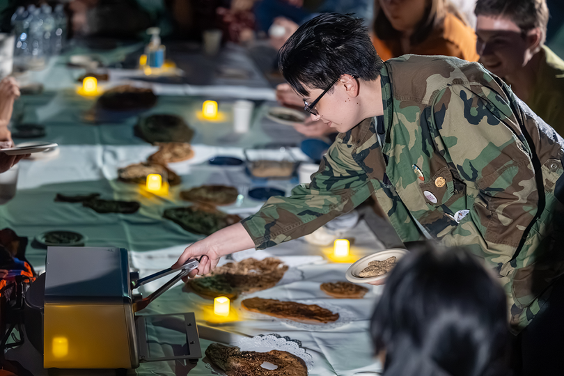 An attendee of "Guerrilla Bread: Special Event with Zelikha Zohra Shoja” uses a toaster oven to bake tandoori bread. Making and sharing bread with people at the event recreated a daily Afghan ritual.