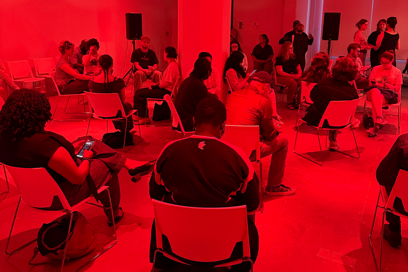 Attendees of Mindy Seu's performance piece "A Sexual History of the Internet" follow along on their phones. The participatory lecture features auto-playing Instagram stories, with audience members reading portions aloud.