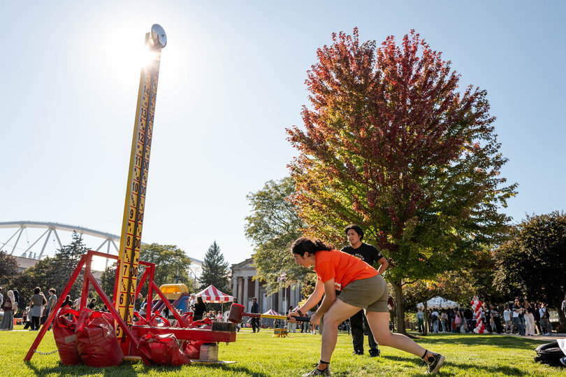 At University Union's first Quad-A-Palooza, an attendee uses a mallet for a high striker game. Quad-A-Palooza replaced UU's Juice Jam music festival.