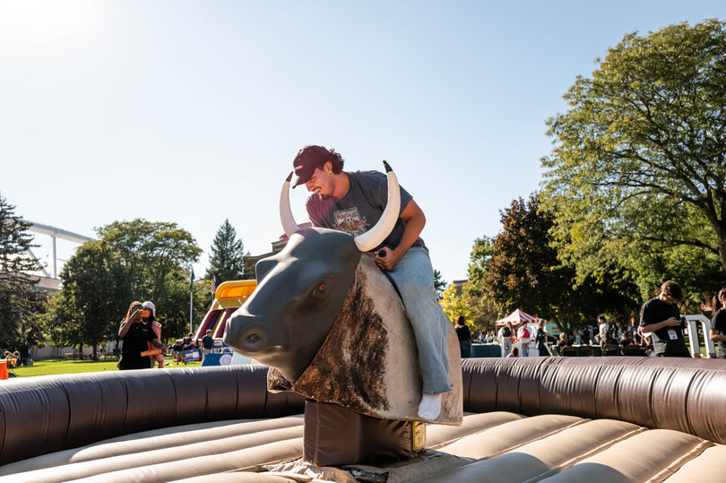 A student rides a mechanical bull on Shaw Quadrangle. The mechanical bull was one of the main attractions at University Union’s inaugural Quad-A-Palooza.