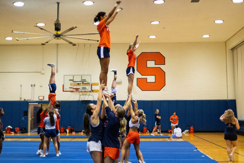 Four stunt groups on the Syracuse University cheer team practice their routine for an upcoming competition in Daytona Beach, Florida. The team is preparing its competition routine alongside its regular game day responsibilities.