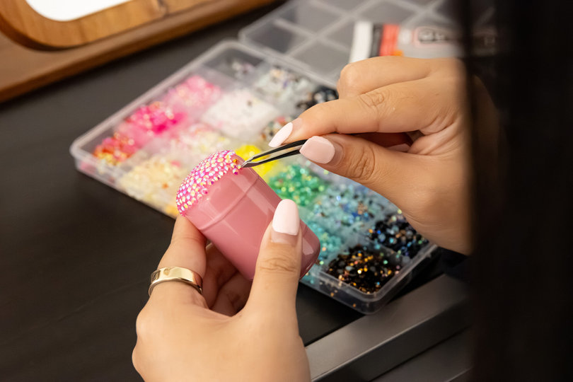 Syracuse University junior Rebekah Oh bedazzles a makeup product. Inspired by a friend from home, Oh also decorates Sonny Angels with gems and bedazzles gifts for loved ones.