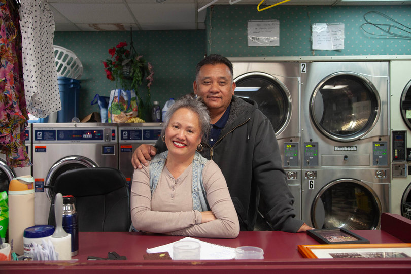 Ray and Xai Uon pose inside their business Caraway Cleaners. The couple manages laundry orders for various Syracuse University students.